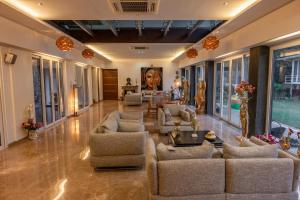 a large living room with couches and chairs at amã Stays & Trails Butterfly Villa, Deolali, Nashik in Nashik