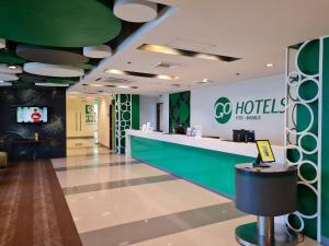 a lobby of a hotel with a reception counter at Go Hotels Otis - Manila in Manila