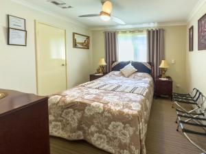 柏斯的住宿－阿斯科特天鵝住宿加早餐旅館，一间卧室配有一张床、两盏灯和一个窗户。