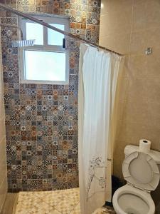 a bathroom with a toilet and a window at Cabañas Gardenias 2 in Zacatlán