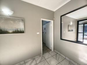 a hallway with a mirror and a painting on the wall at Mitchell Guesthouse in Pietermaritzburg