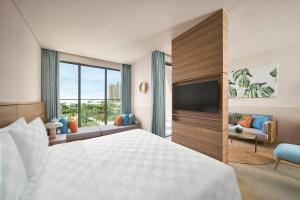 um quarto de hotel com uma cama e uma televisão em IXORA Ho Tram By Fusion em Ho Tram
