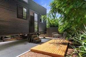 una casita en una terraza de madera con una silla en Faraway Retreat, en Urangan