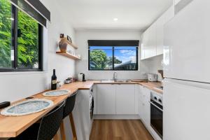 uma cozinha com armários brancos e um balcão de madeira em Faraway Retreat em Urangan