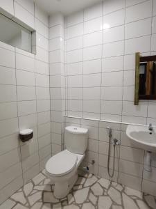a white bathroom with a toilet and a sink at 7 Wooden Lodge Ipoh City in Ipoh