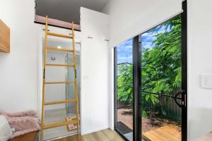 Habitación con una puerta de cristal que da a un balcón. en Faraway Retreat, en Urangan