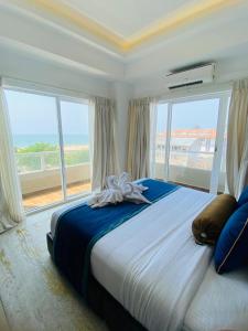 a bedroom with a large bed with a large window at Corundum Breeze Negombo in Negombo