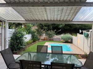 a patio with a table and chairs and a swimming pool at Ripplewood in Vereeniging