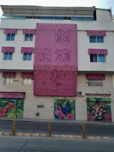 un edificio con una pared rosa a un lado. en HOTEL SAN ANTONIO PLAZA, en Cali