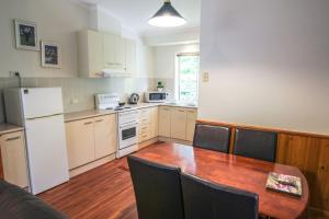 a kitchen with a table and a white refrigerator at Silver Birches Holiday Village - Unit 2 in Bright