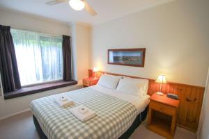 a bedroom with a bed with two towels on it at Silver Birches Holiday Village - Unit 2 in Bright +13 photos