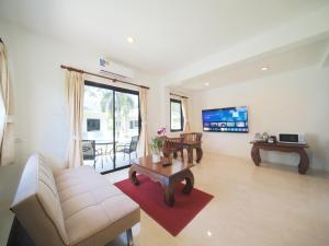 a living room with a couch and a table at Isara Nai Yang resort in Nai Yang Beach