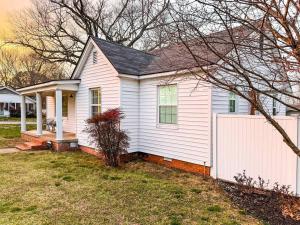 a white house with a white fence in a yard at The Grate House - Fire Table - Grill - Fenced Yard in Searcy