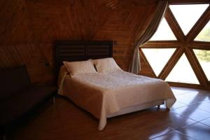1 dormitorio con cama y ventana grande en Domo en Viña Sanroke, en Río Claro