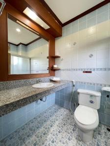 ein Badezimmer mit einem WC, einem Waschbecken und einem Spiegel in der Unterkunft Sea View Resort Rayong in Rayong