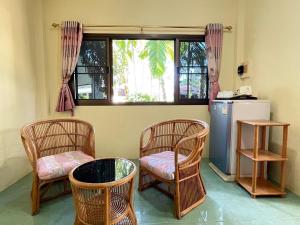 eine Küche mit 3 Stühlen, einem Tisch und einem Fenster in der Unterkunft Sea View Resort Rayong in Rayong