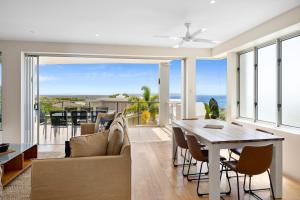 彩虹海灘的住宿－彩虹海洋棕櫚度假酒店，客厅配有桌椅,享有海景。
