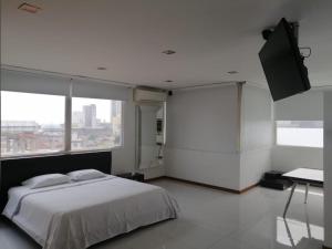 a bedroom with a bed and a flat screen tv at HOTEL SAN ANTONIO PLAZA in Cali