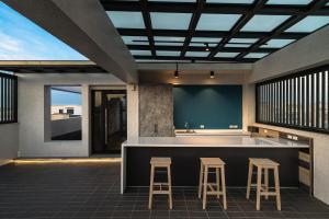 uma cozinha exterior com dois bancos e um bar em Antler Guest House em Magong