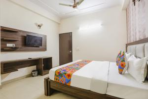 a bedroom with a bed and a flat screen tv at FabHotel Corporate Stay in Noida