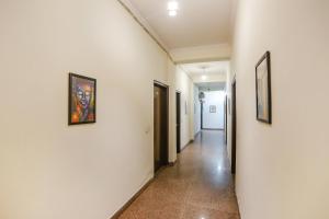 un pasillo con paredes blancas y pinturas en las paredes en FabHotel Corporate Stay en Noida