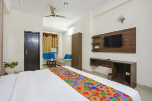 a hotel room with a bed and a television at FabHotel Corporate Stay in Noida
