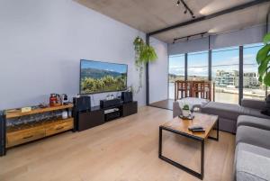 uma sala de estar com um sofá e uma televisão de ecrã plano em Stunning 1BR Apartment with Water Views em Kingston 