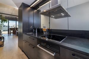 een keuken met een zwart aanrecht en een fornuis bij Stunning 1BR Apartment with Water Views in Kingston 