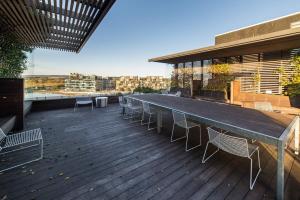 una terraza con una mesa larga y sillas en un edificio en Stunning 1BR Apartment with Water Views en Kingston 