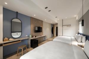 馬公市にあるAntler Guest Houseのベッド2台と鏡が備わるホテルルームです。