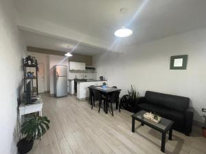 een woonkamer met een zwarte bank en een keuken bij Cielos del valle in Salta
