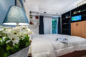 a bedroom with a bed with white flowers and a lamp at Cozy Apartment in Athens 3 km from Acropolis, 5km form the beach in Athens
