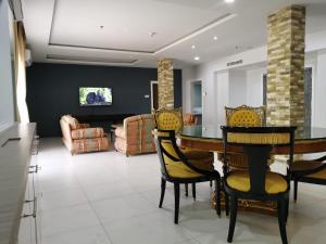 Century Langkasuka Resort Langkawi في بانتايْ سينانج: غرفة معيشة مع طاولة وكراسي