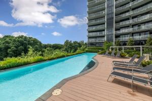 a swimming pool with chairs and a building at Sky High Views in the Heart of Canberra in Canberra