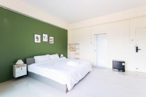 Ban Khlong HaeにあるHatyai Humble Home 02の緑の壁のベッドルーム1室(白いベッド1台付)