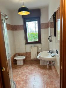 baño con lavabo y aseo y ventana en Conte Durini Apartments & Rooms, en Arcore