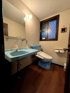 a bathroom with a blue sink and a toilet at 绿之村豪華な天然温泉リゾートマンション 和モダンと和の融合 bbq を満喫 山林の湯の風雅 in Hakone