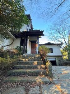 una casa con escaleras que conducen a una puerta en 绿之村豪華な天然温泉リゾートマンション 和モダンと和の融合 bbq を満喫 山林の湯の風雅, en Hakone