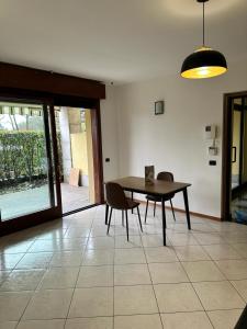 uma sala de jantar com uma mesa e cadeiras num piso de azulejo em Conte Durini Apartments & Rooms em Arcore