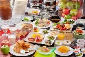 Hotel Apple Land في Hirakawa: طاولة مع العديد من الأطباق من المواد الغذائية والمشروبات