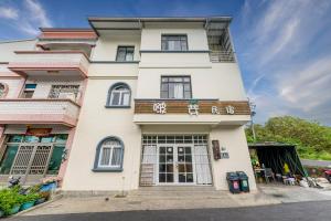 a tall white building with a balcony at Bo Ya Homestay in Xiaoliuqiu