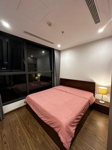 ein Schlafzimmer mit einem Bett und einem großen Fenster in der Unterkunft Vinhomes West Point homestay in Hanoi