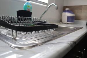 a dish drying rack sitting on top of a kitchen sink at Departamento en Guadalupe in Monterrey