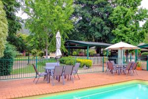 a patio with tables and chairs next to a pool at Silver Birches Holiday Village - Unit 3 in Bright
