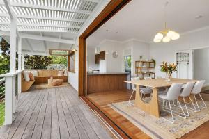 a dining room and kitchen with a table and chairs at Daisy's Beach House - 16 Burns St Byron Bay in Byron Bay