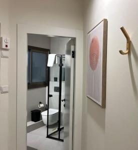 a bathroom with a toilet and a mirror at Garden House By IsrApart in Ra‘ananna