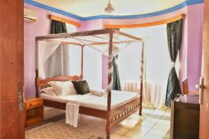 a bedroom with a canopy bed in a room at tulia liqizo homestay in Mombasa