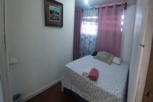 a small bedroom with a small bed and a window at Victoria s Beach House and Snorkeling Center in Roatan