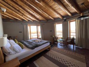 a bedroom with a bed in a room with windows at Dakpa House Ladakh in Ranbirpura