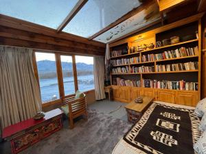 a bedroom with a room with bookshelves and a window at Dakpa House Ladakh in Ranbirpura